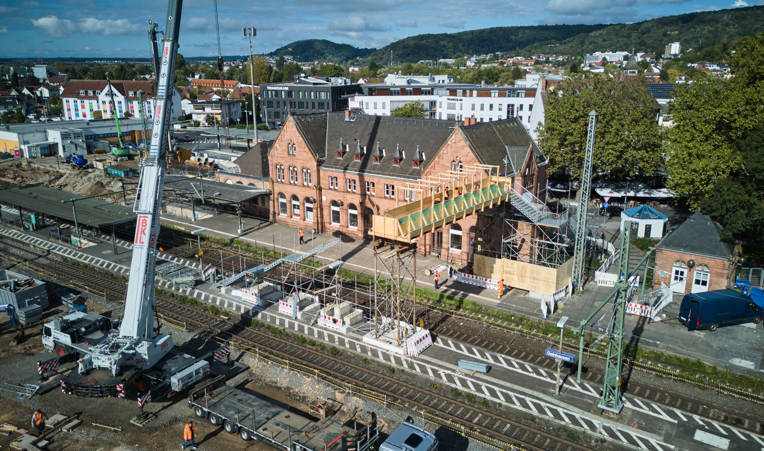 Luftbild des Bahnhofs Gelnhausen. Links vorne ein Mobilkran, auf dem Mittelbahnsteig Baumaterial.